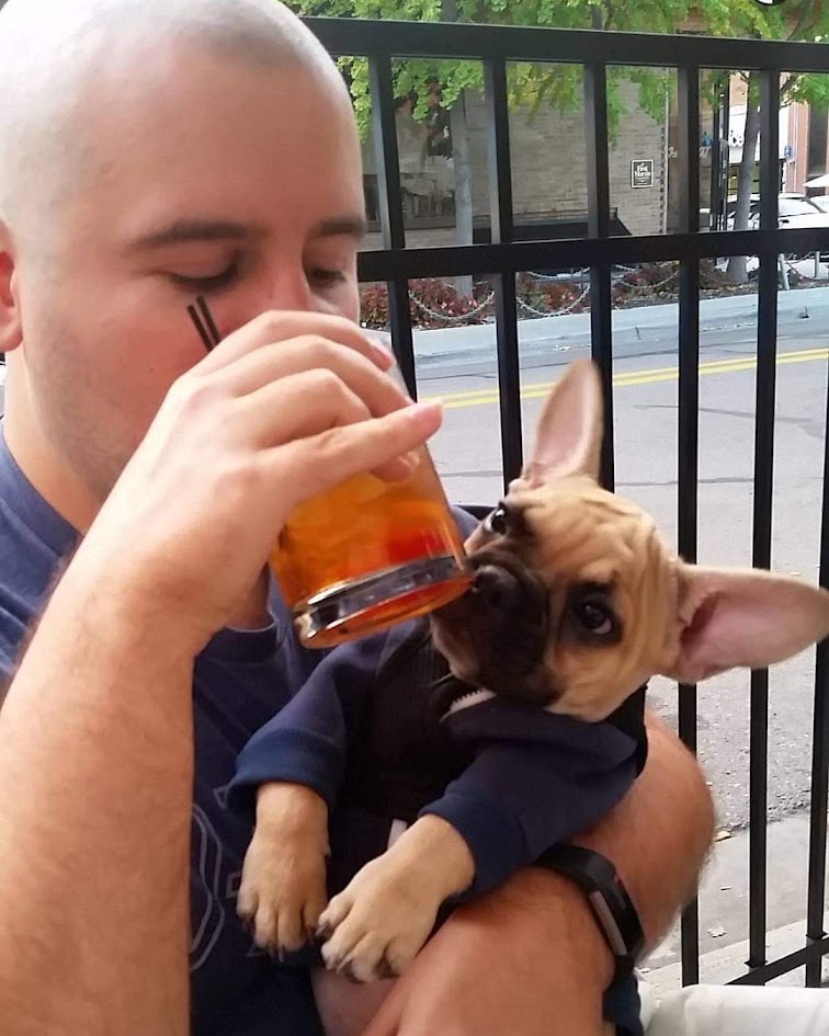 Andrew holding Hubert, his fawn French bulldog, outdoors